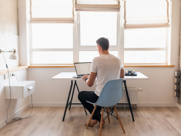 hombre-guapo-joven-moderno-traje-casual-sentado-mesa-trabajando-computadora-portatil-autonomo-casa
