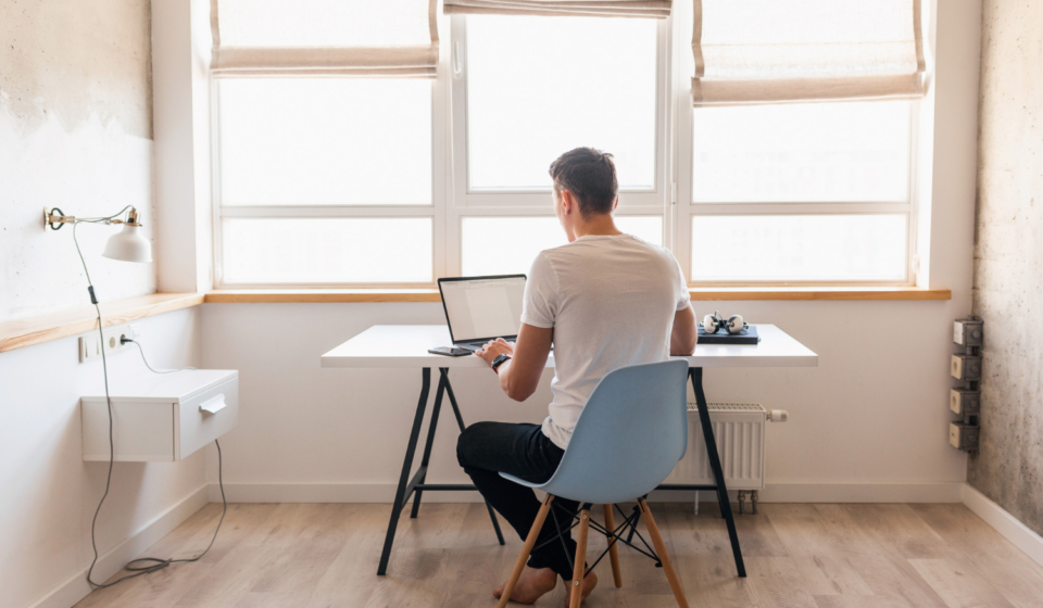 hombre-guapo-joven-moderno-traje-casual-sentado-mesa-trabajando-computadora-portatil-autonomo-casa